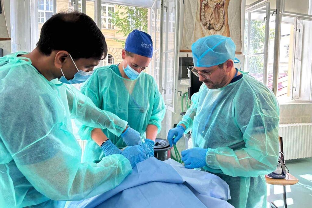 Instructor leading a practical training session with a cadaver as part of the AEMIS emergency medical course